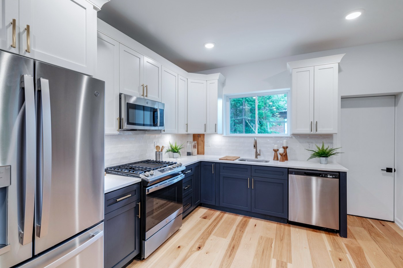 Renovated kitchen at 710 S Frazier St, navy cabinets with white uppers and brass pulls