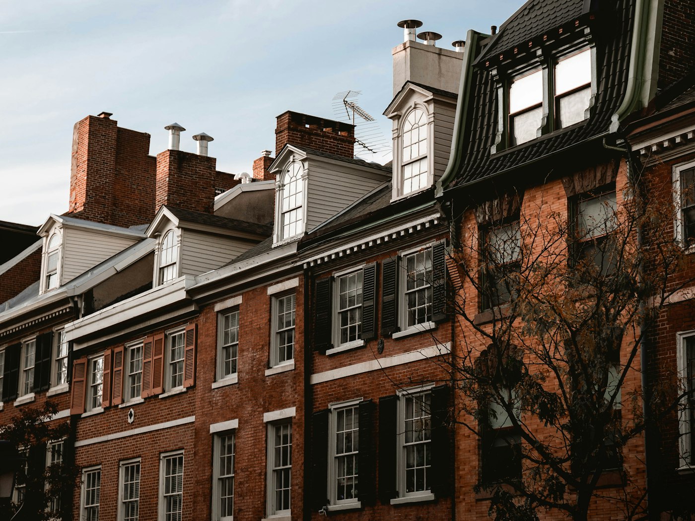 Row of historic brick townhouses with dormers in Philadelphia