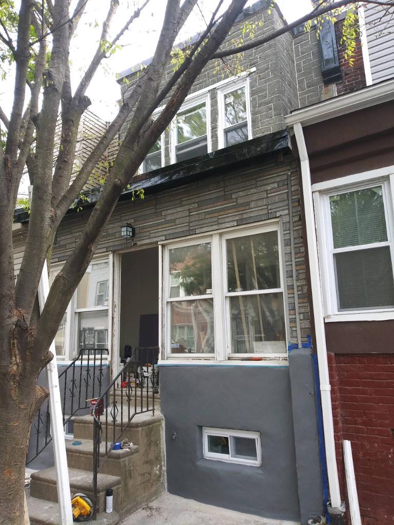 Exterior stucco and window work in progress during the 1526 S Vogdes St renovation